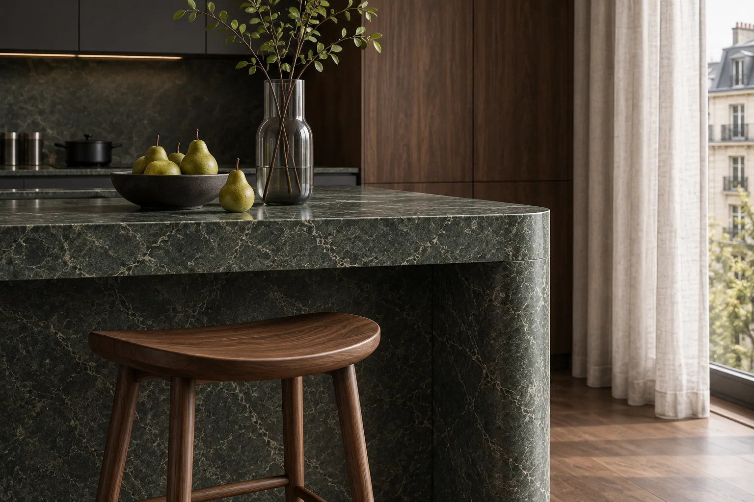 Green stone island corner, walnut stool and ceramic bowl of pears.